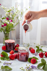 Wall Mural - Fresh homemade strawberry jam in glass jar on a light background.