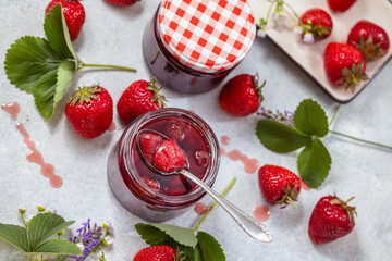 Wall Mural - Fresh homemade strawberry jam in glass jar on a light background.