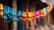  a line of colorful beads hanging from a line of wooden poles in front of a building with a wooden door in the back ground and a row of colorful beads hanging from a line.