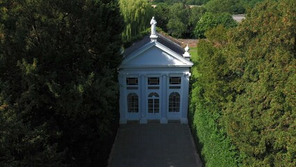 Aerial top down view from the drone onto the narrow passageway leading to a small chapel. Chapel located in a big green open area of fields near Rosary Manor, Mill Hill, North West London, London, UK.