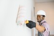 African-American decorator painting light wall