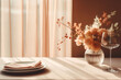 A white table with peach fuzz color flower bouquet in a glass vase a wine glass next to it plates with tissue and a pink curtain background. Dinner set up. Copy space
