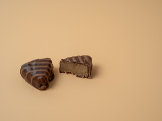 Wall Mural - Chocolate candies on an orange background. Chocolate candies close-up.