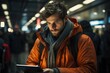© ZenOcean_DigitalArts - Man in Orange Jacket Using Tablet: Intense focus, urban tech life, warm attire, nighttime ambiance, modern connectivity.