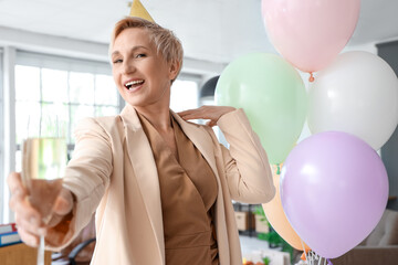 Canvas Print - Mature woman with glass of champagne celebrating her Birthday in office