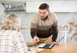 © JackF - Male financial agent tells an elderly woman the terms of microloan. Offers to sign documents