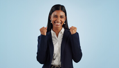 Wall Mural - Winner, excited or happy woman in celebration for a business deal isolated on blue background. Wow, goals or proud Indian lady with smile, victory success or reward in entrepreneurship or studio