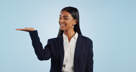 Poster - Happy businesswoman, studio or palm for investment deal, financial offer or product mockup space. Hand, smile or proud Indian corporate worker on blue background marketing, advertising or finance