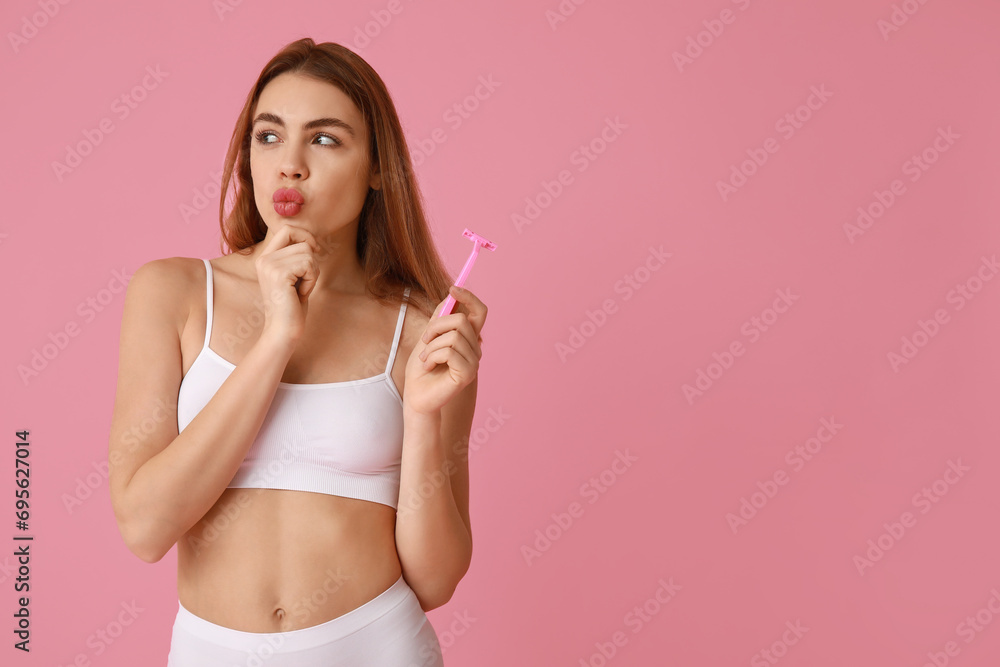 Beautiful young thoughtful woman with razor on pink background