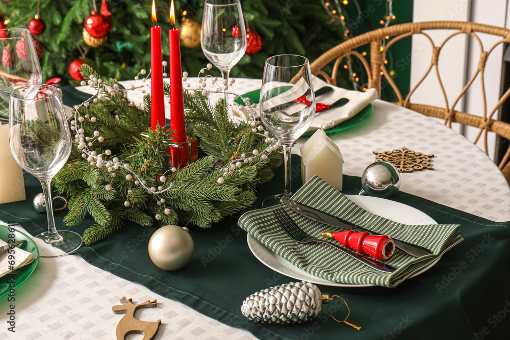 Stylish table setting with Christmas wreath and burning candles, closeup