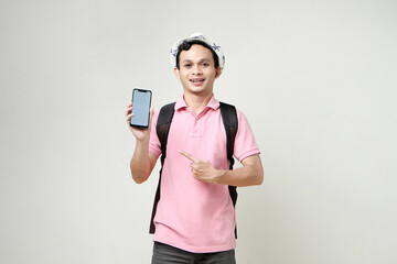Asian man backpacker showing cellphone blank screen with empty space for mobile app on screen. travelling concept. on isolated background