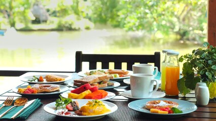 Wall Mural - Fresh breakfast served on sunny patio with assortment of tropical fruits, eggs, bread, and juice. Healthy eating and vacation relaxation.