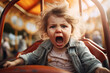Screaming scared shaggy girl child on a carousel in an amusement park