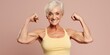 An older woman flexing her muscles in a yellow tank top. Suitable for fitness and healthy lifestyle concepts