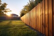 A picturesque scene of a wooden fence in a backyard with the sun setting behind it. Ideal for adding a touch of nature and tranquility to any project