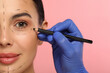 © New Africa - Doctor with pencil preparing patient for cosmetic surgery operation on pink background, closeup