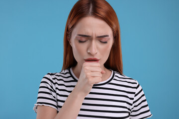 Poster - Woman coughing on light blue background. Cold symptoms