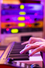 Wall Mural - male musician hands playing midi piano on blurred sound module, audio interface background for recording in studio