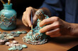 Closeup of turquoise clay figures in young female artist hands