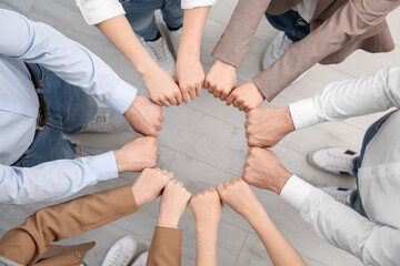 Wall Mural - People holding fists together indoors, top view