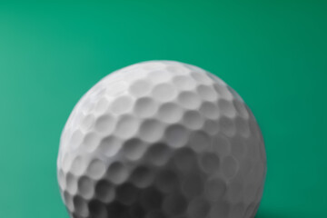 Poster - One golf ball on green background, closeup