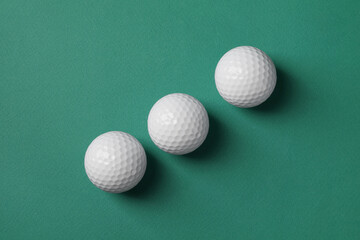 Poster - Three golf balls on green background, flat lay