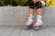 Lonely girl sitting in park, close-up. Child legs with inline skates.