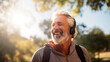 © D-point - Joyful senior Caucasian man with headphones outdoors, ideal for lifestyle and music themes.