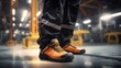 Factory worker wearing safety shoe and working uniform is standing in the factory, ready for working in danger workplace, Safety equipment concept.