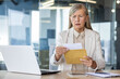 © Liubomir - Businesswoman boss received letter mail notification message with bad news, upset and sad senior woman reading news data , female worker inside office at workplace.