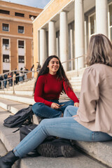 Two student girls sitting on the stairs of the college