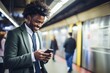Smiling young businessman using smartphone on the metro