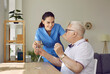 © Studio Romantic - Friendly young female nurse giving medication and glass of water to senior man in nursing home. Friendly young female caregiver worries and cares for her mature male patient. Patient care concept.
