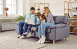© Studio Romantic - Happy young family with two kids girl and boy sitting on sofa using modern laptop together. Smiling parents resting on couch enjoying weekend watching funny cartoon online or talking on video call.