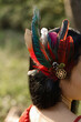Close-up of headdress made bright feathers stylized by North American Indians on head of woman. 