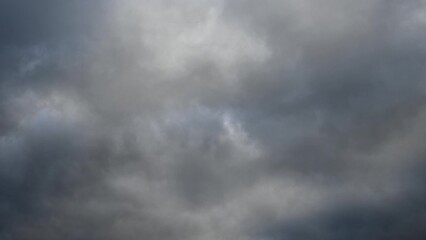 Wall Mural - a time lapse looking up at light to dark gray clouds moving from left to right. only the clouds are 
