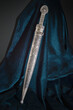 Circassian Adyghe Kama silver dagger on velvet dark material.