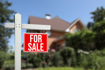 Sticker - Sale sign near beautiful house outdoors. Red signboard with words