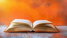 Opened Book On Orange Grungy Background Panoramic Good Copy Space