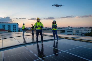 Technician working on ecological solar farm. Renewable clean energy technology concept. Specialist engineer control drone checking top view of installing solar roof panel on the factory rooftop