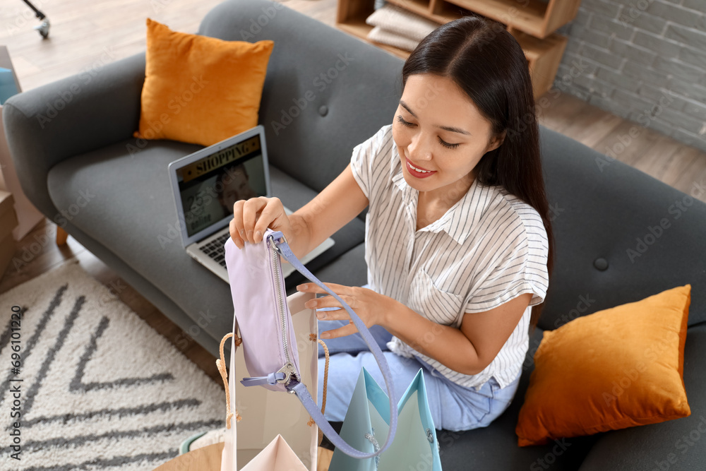 Young Asian woman with new bag at home. Online shopping