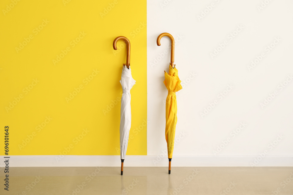 Umbrellas on floor near color wall