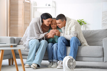 Wall Mural - Frozen family with lack of heating warming hands at home