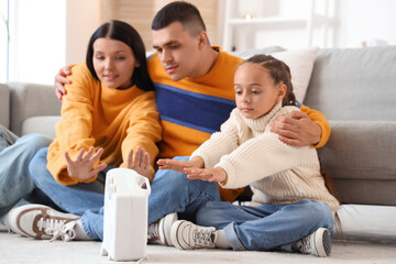 Sticker - Frozen family warming near electric fan heater at home