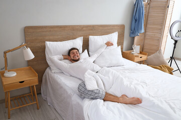 Canvas Print - Young bearded man lying in bedroom