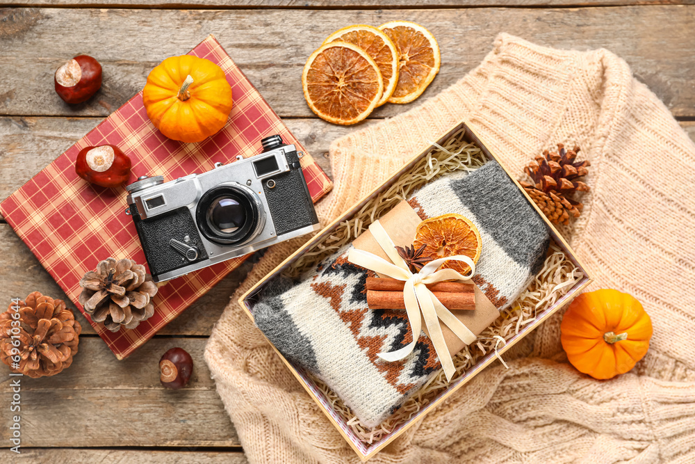 Beautiful composition with warm socks and photo camera on wooden background