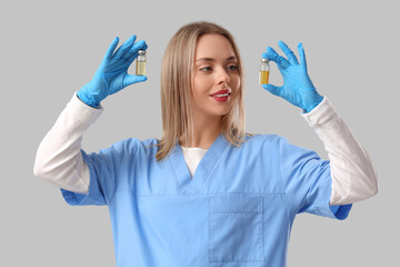 Canvas Print - Female nurse with ampules on grey background. Vaccination concept