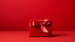 Cadeau rouge sur fond rouge. Espace vide de composition. Ambiance chaleureuse. Saint-Valentin, Noël, anniversaire. Plaisir, offrir. Arrière-plan pour conception et création graphique.