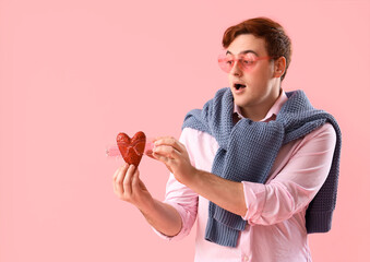 Sticker - Surprised young man with sunglasses and heart on pink background. Valentine's Day celebration