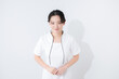 白いナース服を着た美容や医療などの若い女性看護師のお辞儀の上半身の白背景